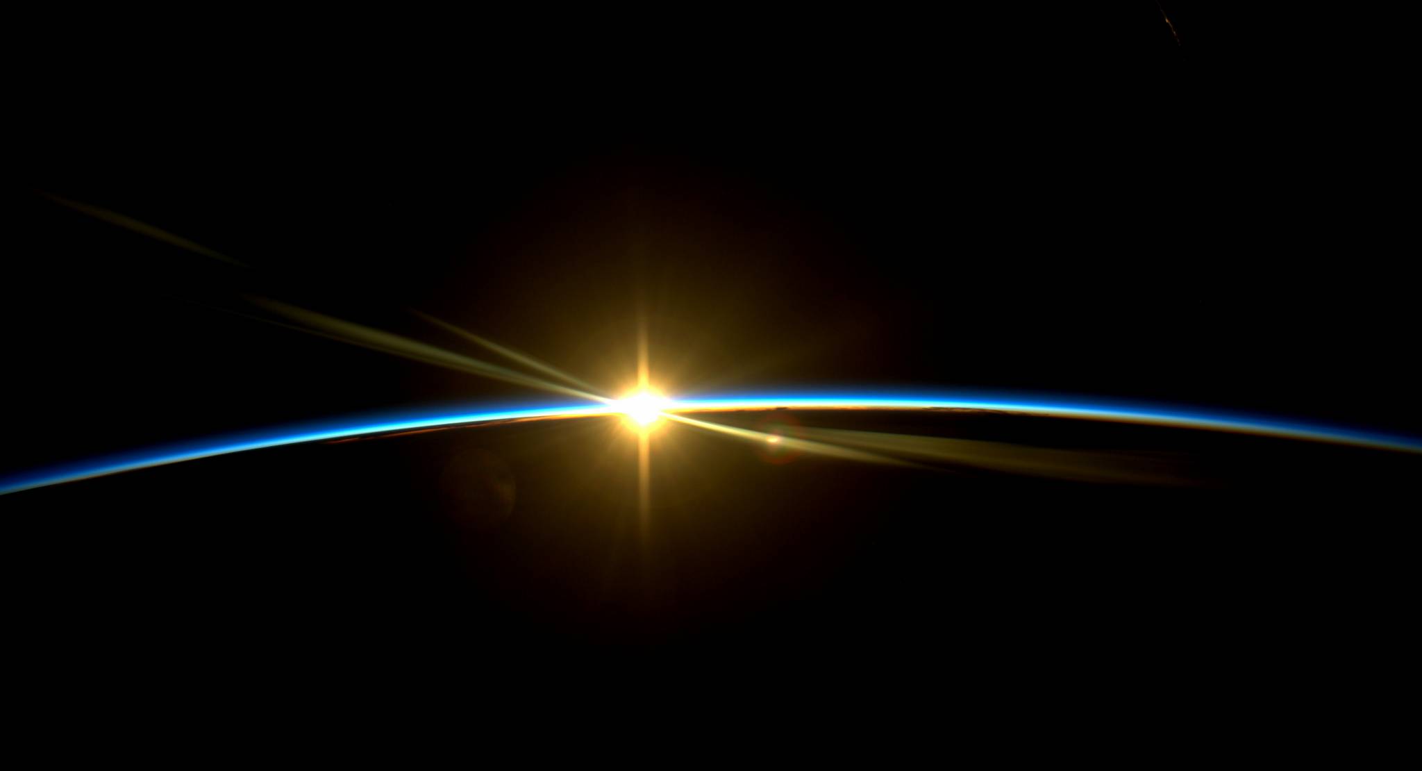 Sonnenaufgang über der dunklen Erde aus Sicht der internationalen Raumstation ISS